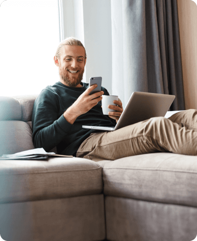 man sitting on couch drinking coffee